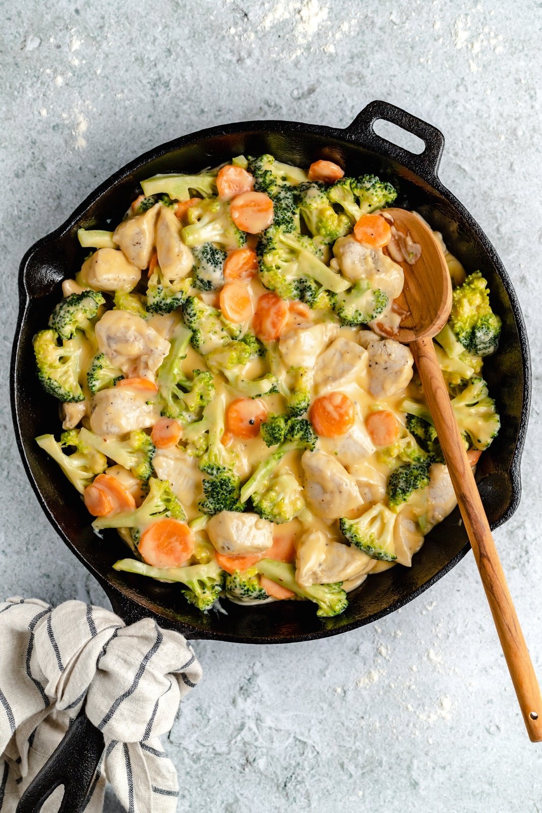 cooking chicken, broccoli and veggies in a skillet for broccoli cheddar chicken pot pie