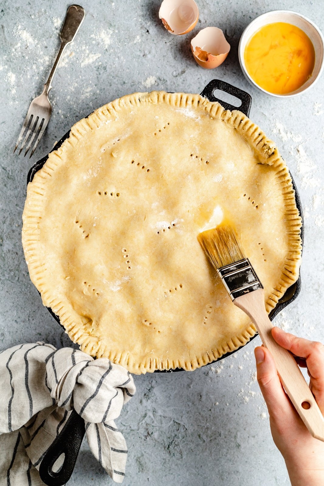 brushing a cheddar broccoli chicken pot pie crust with an egg wash