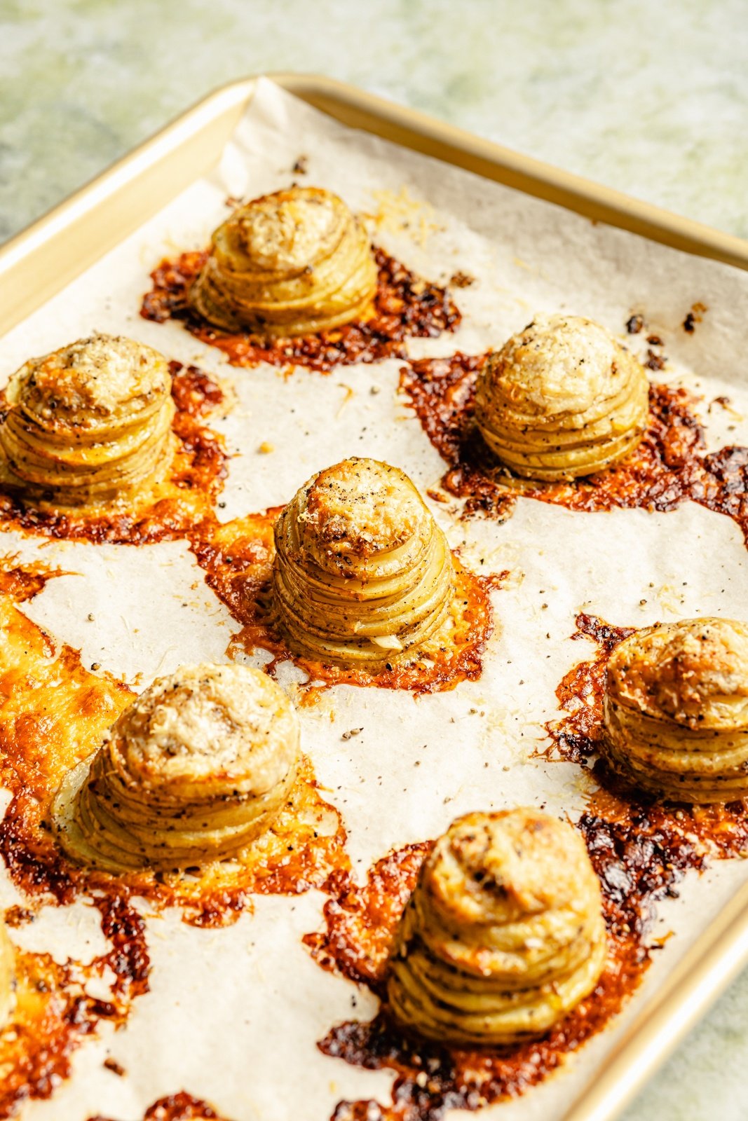 cheesy stacked potatoes on a baking sheet