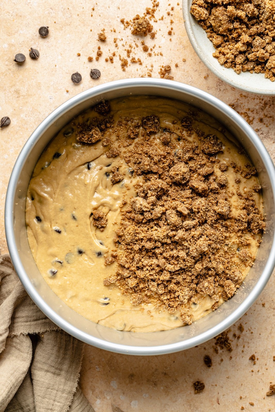 topping an unbaked espresso chocolate chip coffee cake with streusel