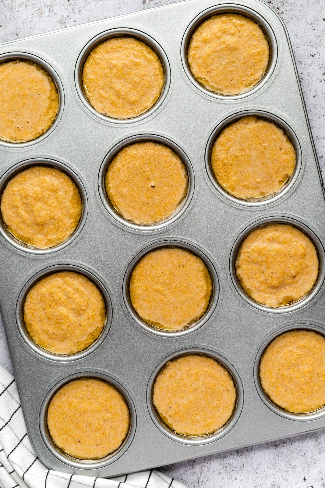 unbaked gluten-free cornbread muffins in a muffin tin