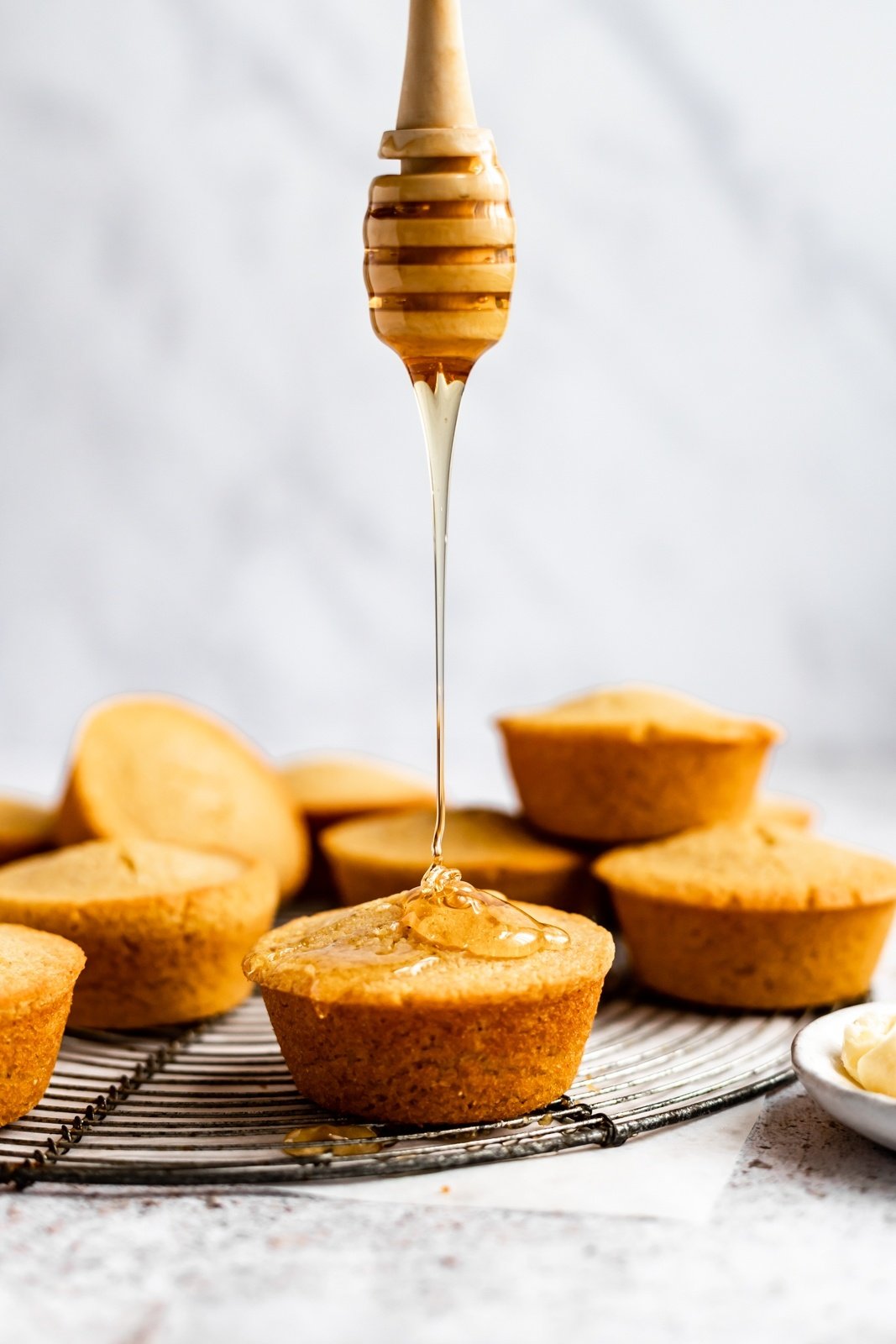 drizzling honey on a gluten free cornbread muffin