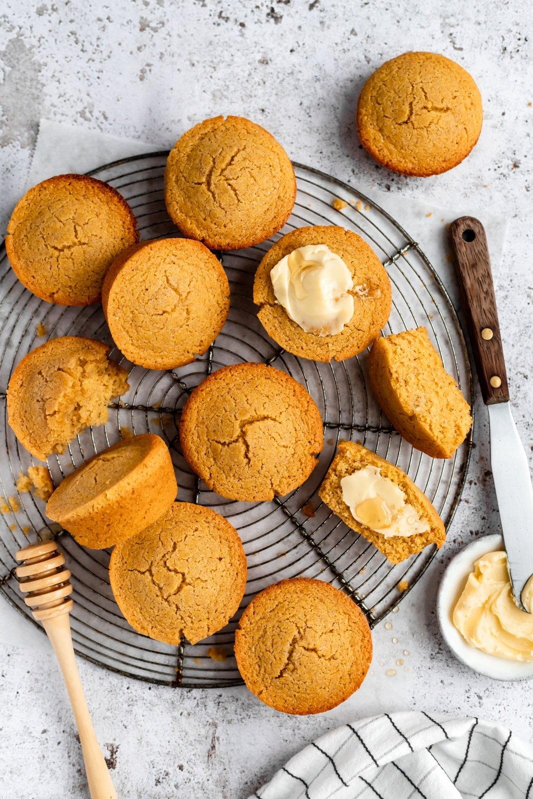 gluten-free cornbread muffins on a wire rack with butter