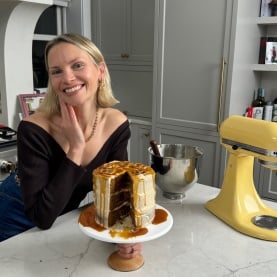 monique volz of ambitious kitchen holding a cake