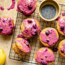 healthy lemon poppy seed muffins with blueberry glaze on a wire rack