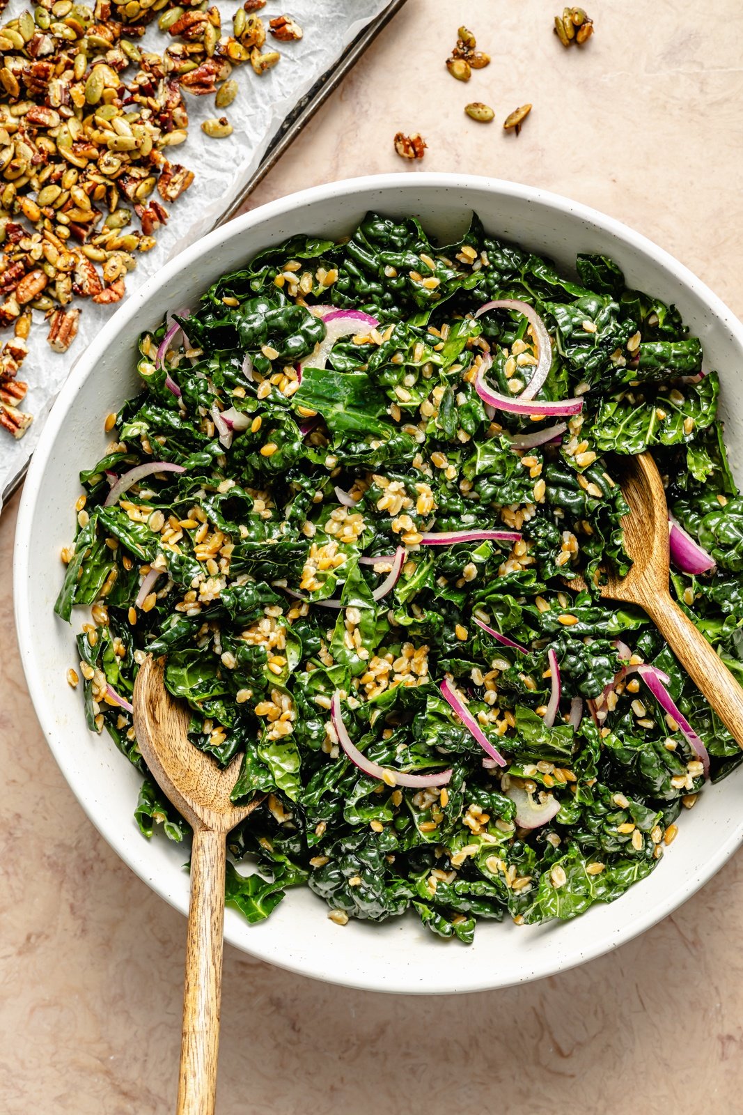tossing an apple farro salad in a bowl