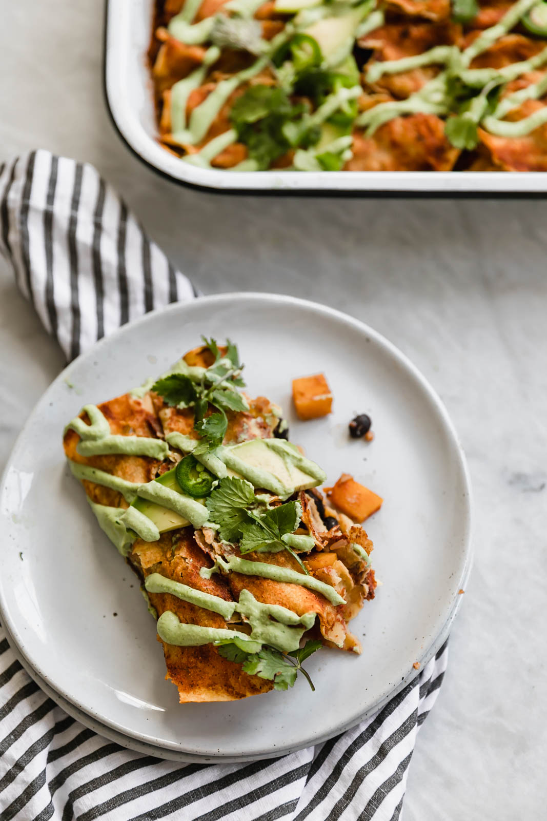 black bean enchiladas on a plate drizzled with jalapeño cashew crema
