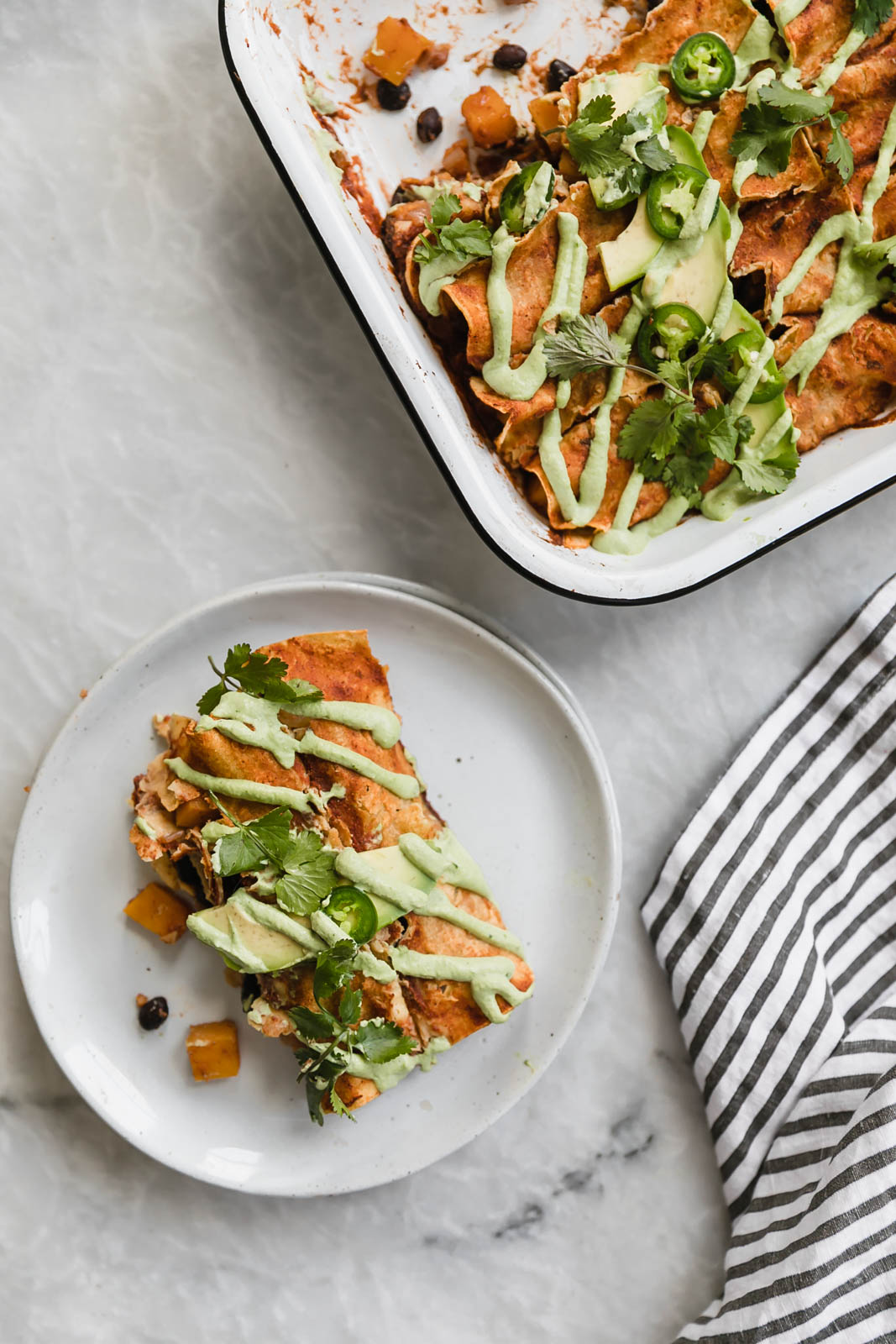 vegan butternut squash enchiladas in a baking dish and on a plate