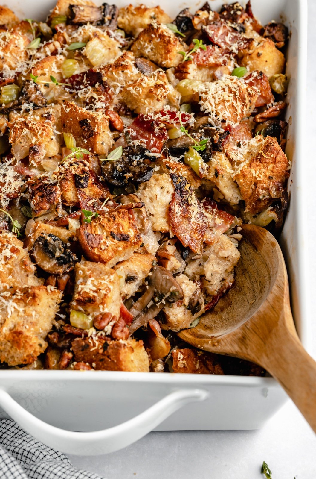 sourdough mushroom stuffing in a baking dish with a wooden spoon