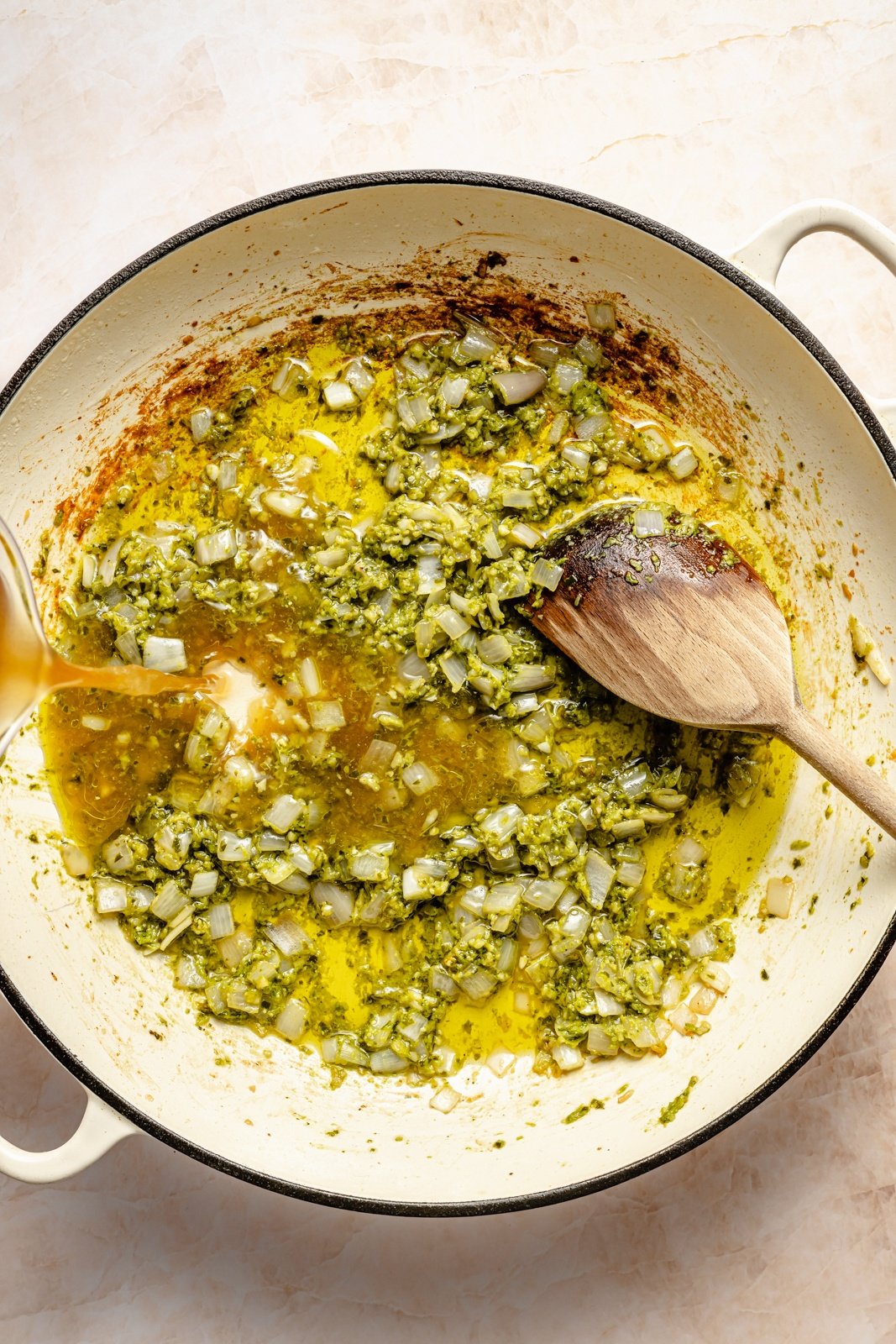 cooking vegetables in a pan for a caprese orzo bake