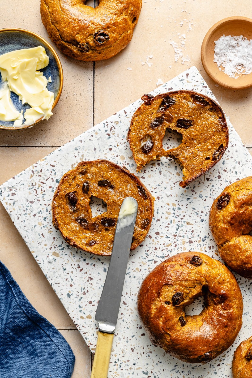 sliced protein pumpkin bagel spread with butter on a board