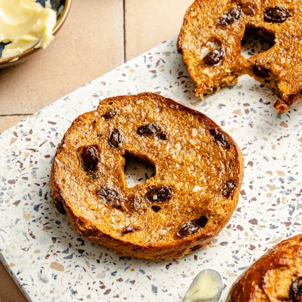 pumpkin protein bagel cut in half on a board