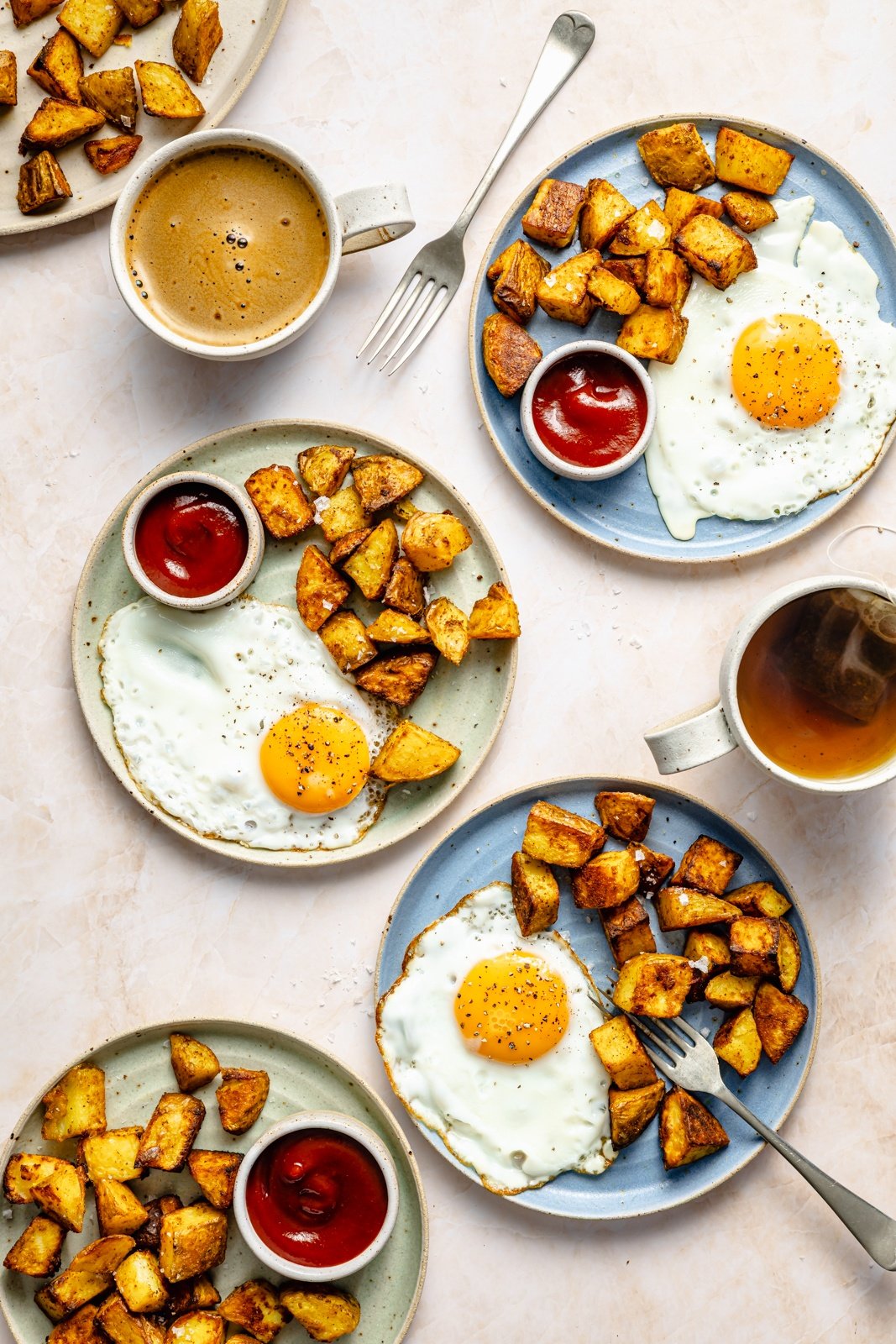plates with crispy breakfast potatoes, eggs and ketchup
