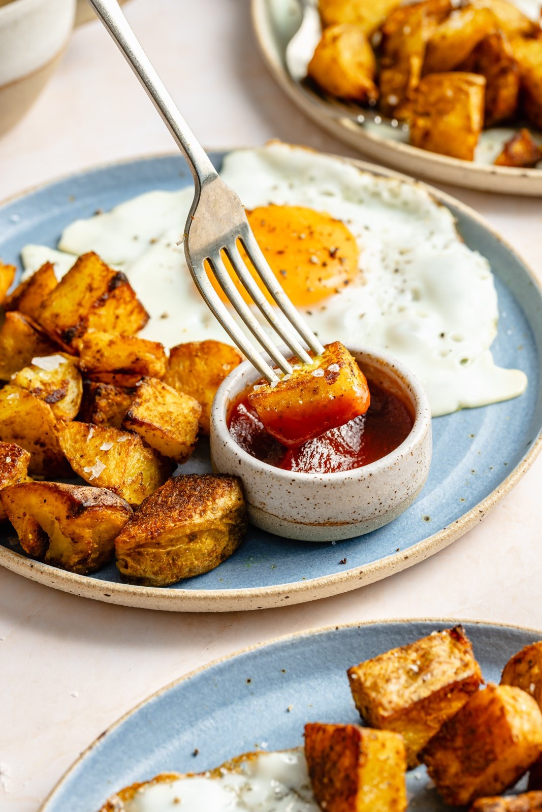 dipping a breakfast potato in ketchup