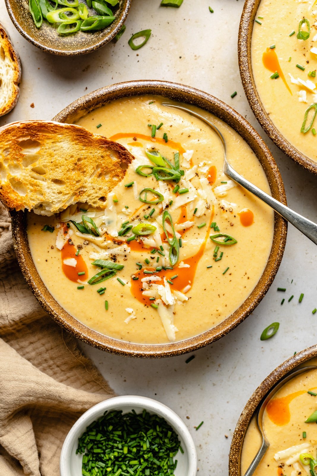 buffalo cauliflower soup in a bowl with a piece of toasted bread