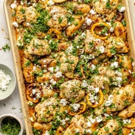 sheet pan lemon chicken and potatoes toped with herbs and feta