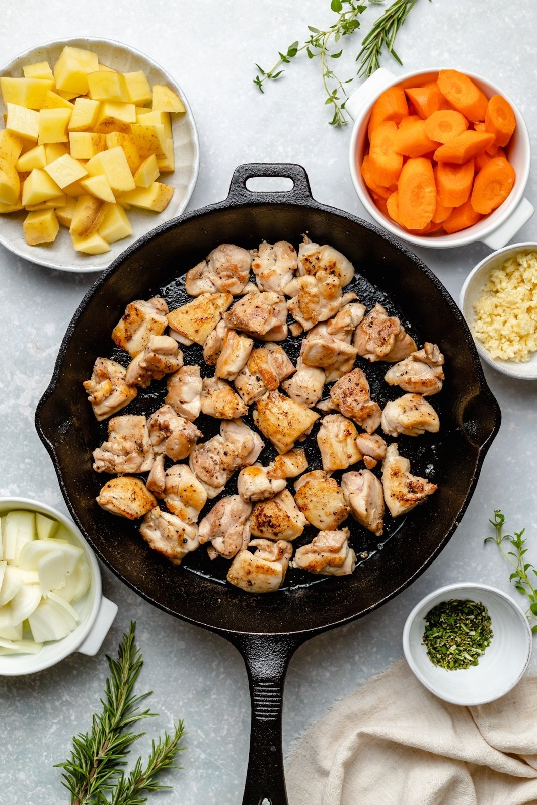 ingredients for slow cooker white wine chicken stew in a skillet and in bowls