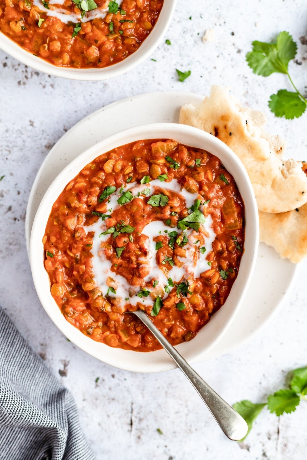 vegan tomato lentil soup in a bowl with naan