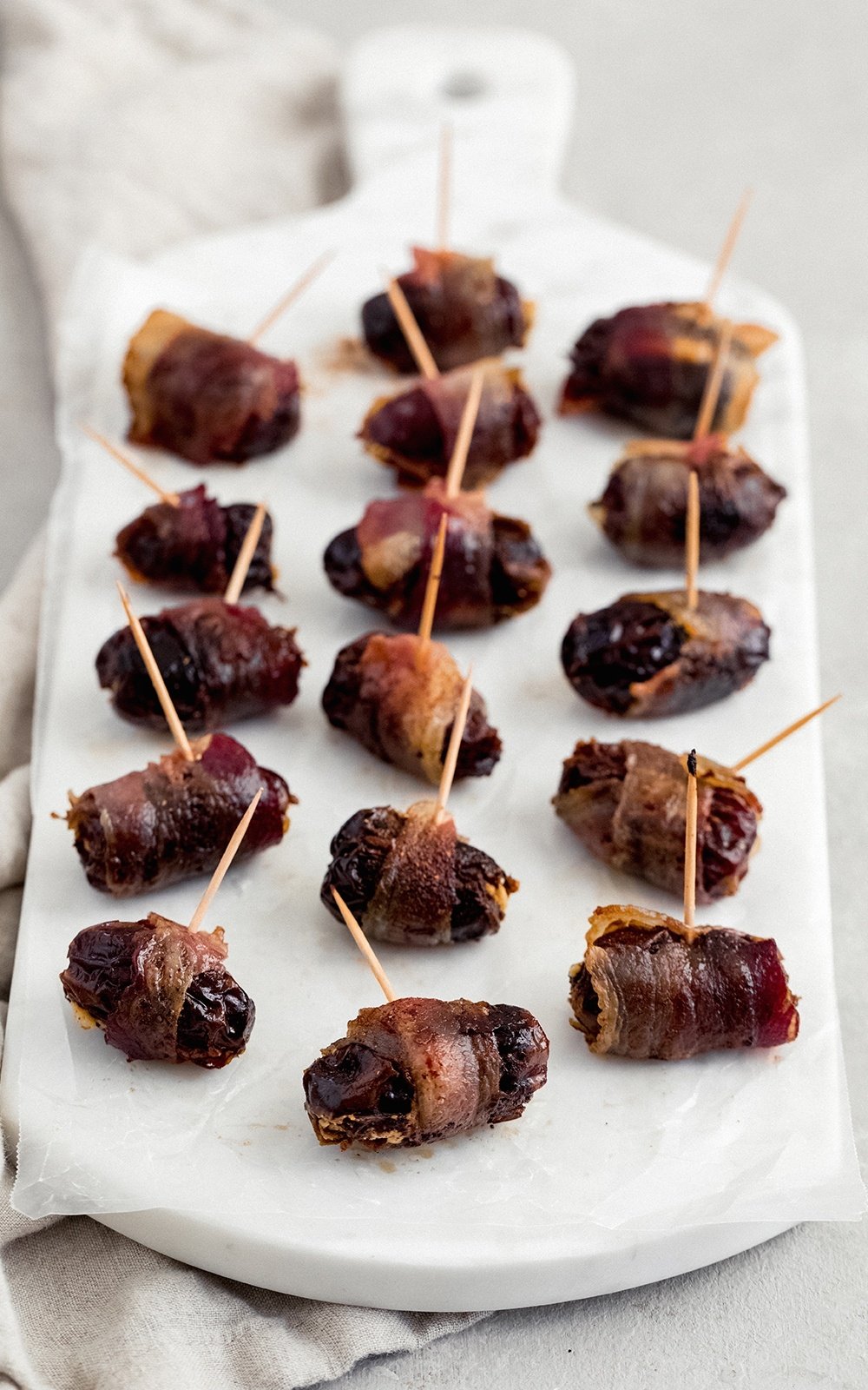 goat cheese stuffed dates with bacon on a marble serving tray
