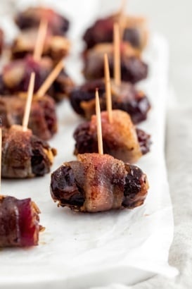 bacon wrapped dark chocolate and goat cheese stuffed dates on wax paper