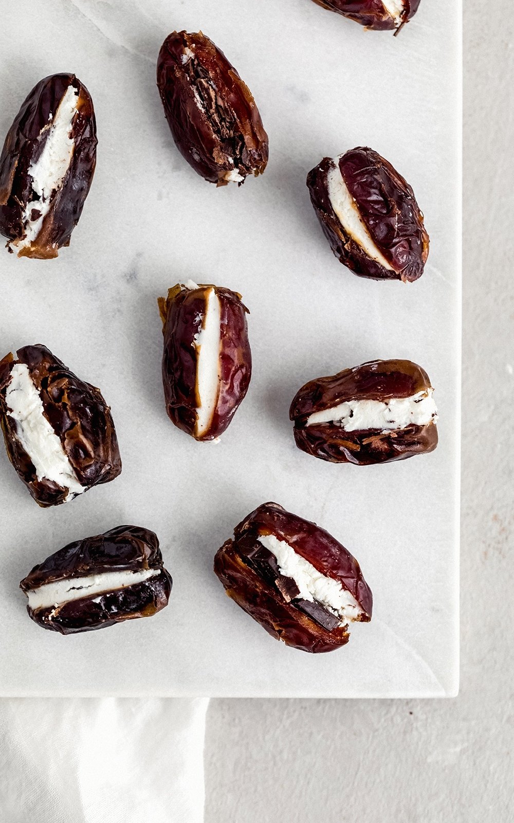 goat cheese stuffed dates on a marble board